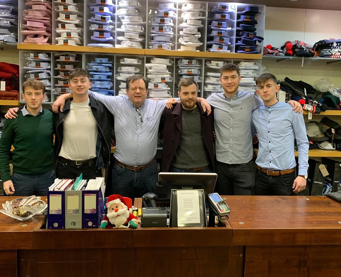Staff lined up in front of the shirt shelves at Christmas